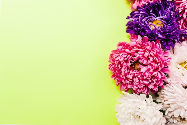 Composizione di fiori fiori viola e viola su sfondo giallo cornice fatta di fiori san valentino festa della mamma festa della donna primavera estate concetto piatto laico vista dall'alto spazio copia