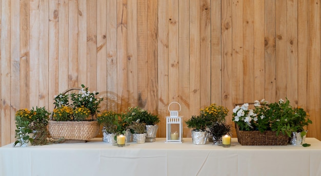 Flowers decorate on the dinning long table in the luxury relax event with the wood plate background