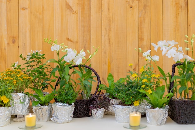 Flowers decorate on the dinning long table in the luxury relax event with the wood plate background.