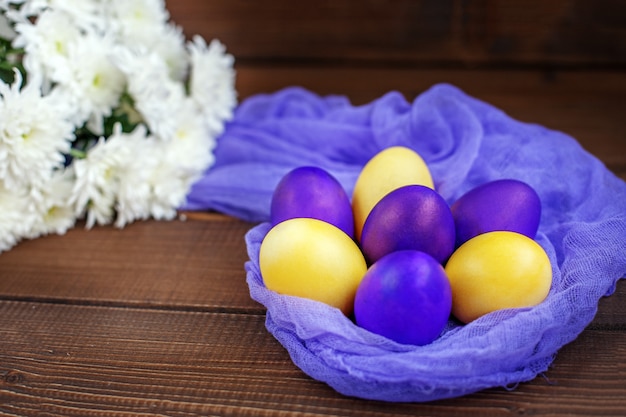 Flowers and eggs on a wooden background. Concept Happy Easter.