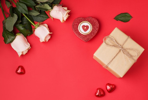 Flowers and gift box on red background