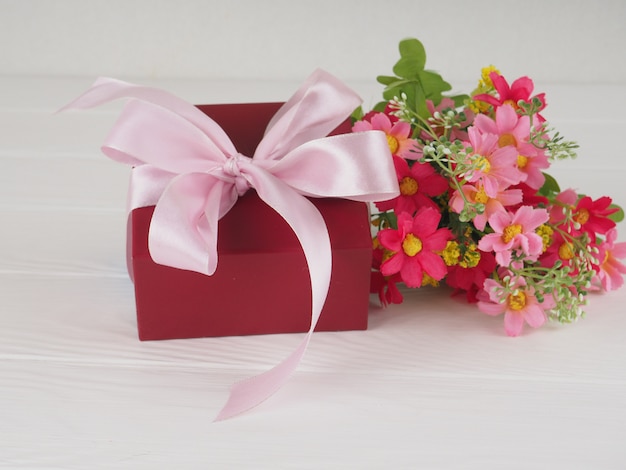 Photo flowers and gift box on wooden rustic table. mother or valentines day greeting card. copy space for text.