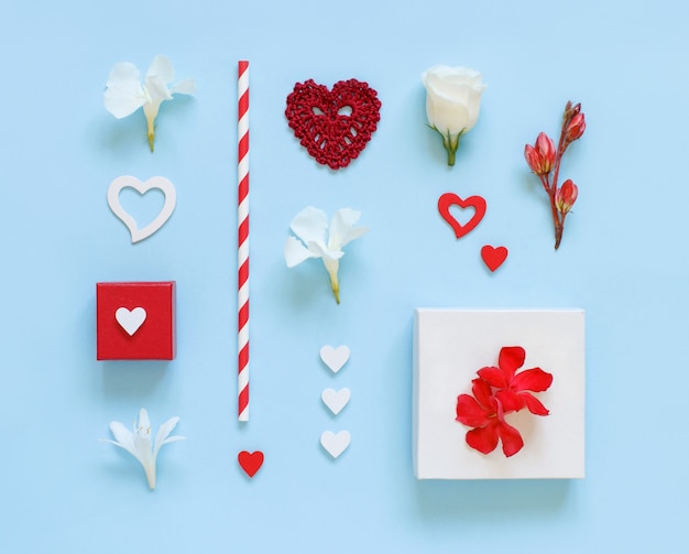 Flowers, gift boxes and hearts on a light blue top view