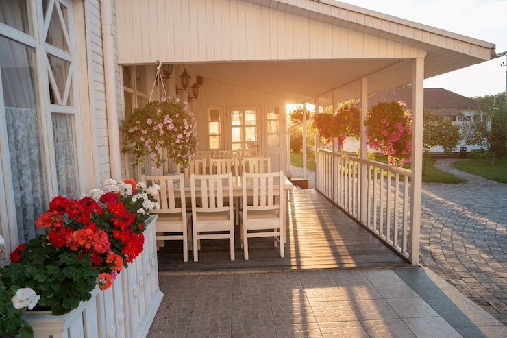 Photo flowers hanging on a porch white colored house and sunlight time to come back home remember those wh