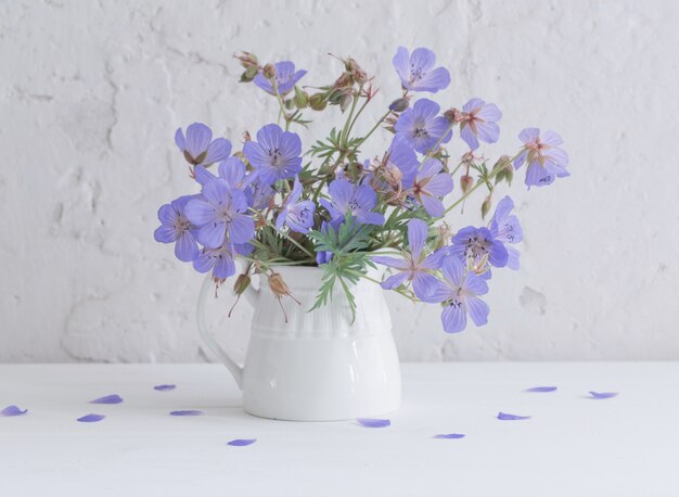 Flowers in jug on white surface