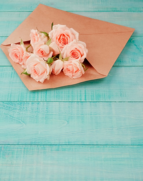 Photo flowers in a kraft envelope, copy space, blue background