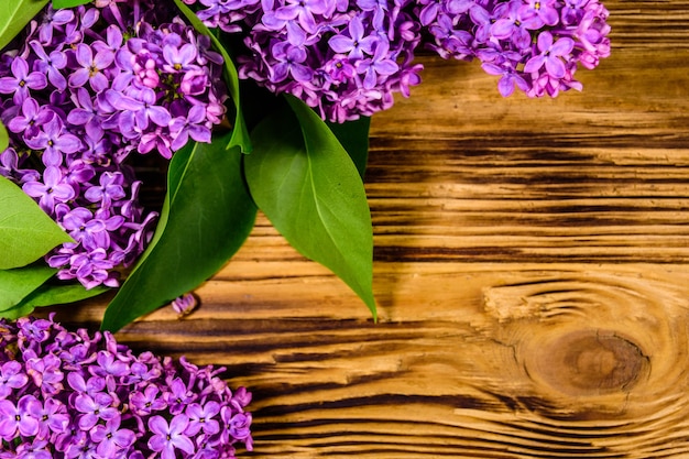 Flowers of lilac plant on a wooden background. Top view