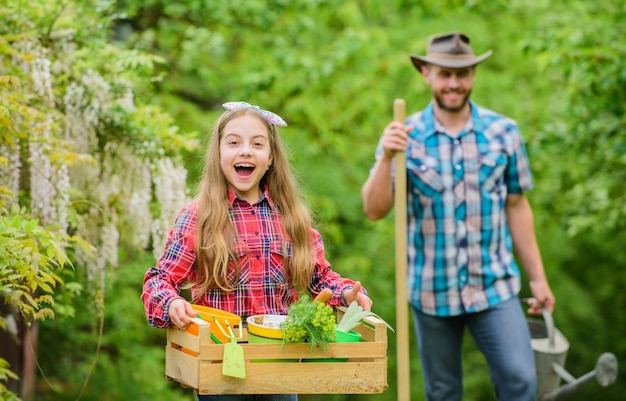 Flowers need good care ecology Gardening tools little girl and happy man dad earth day spring village country family farm father and daughter on ranch Nature needs your care