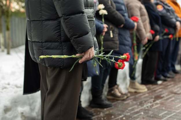 Flowers in old mans hand at funeral details of funeral ceremony commemorative flowers