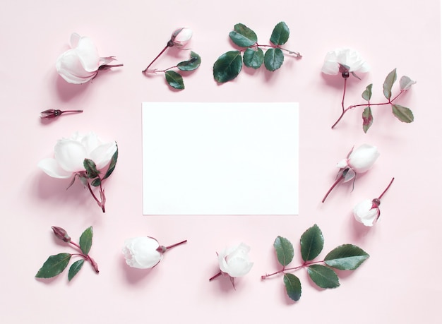 Flowers and paper on a light pink top view retro