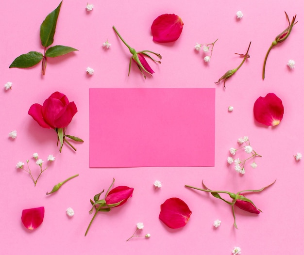 Flowers and petals on a light pink background top view