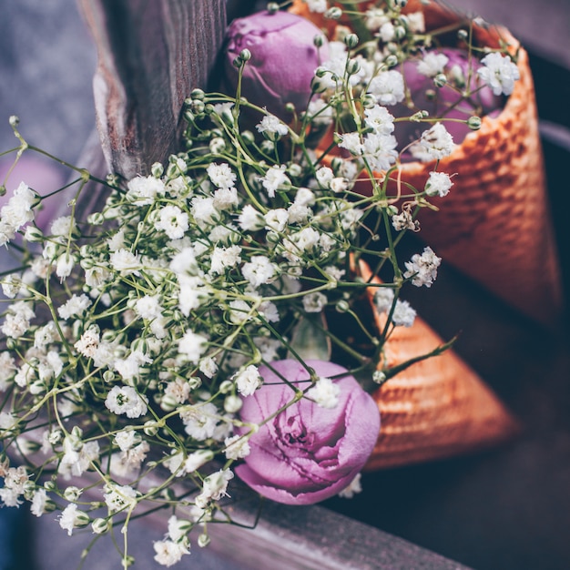 Photo flowers and pink rose in waffle cone in wooden box