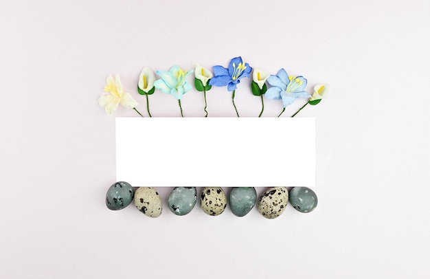 Flowers and quail eggs peek out from under paper models