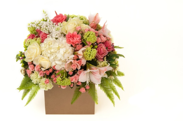 Flowers roses and carnation in cardboard box on a white background. Valentine's Day