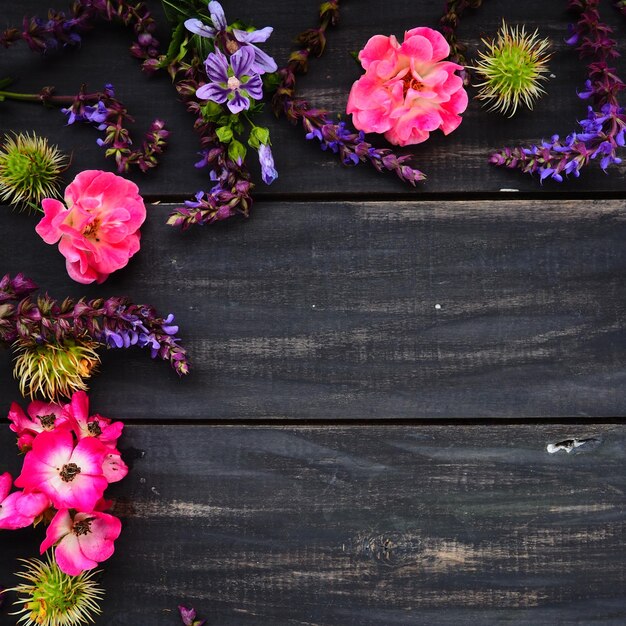 Flowers in a semicircle on a wooden background postcard for the holiday roses lavender sage and hair