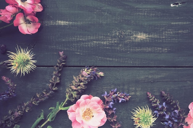 Цветы полукругом на деревянном фоне Открытка к празднику Розы лаванды, шалфея и мохнатых каштанов по краям на темных досках