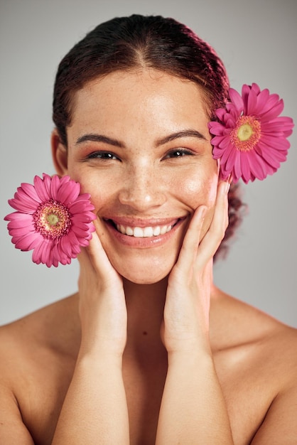 Flowers skincare and face portrait of a woman with natural beauty and a smile for dermatology Facial wellness and self care for skin glow nature cosmetics or makeup of a healthy model in studio