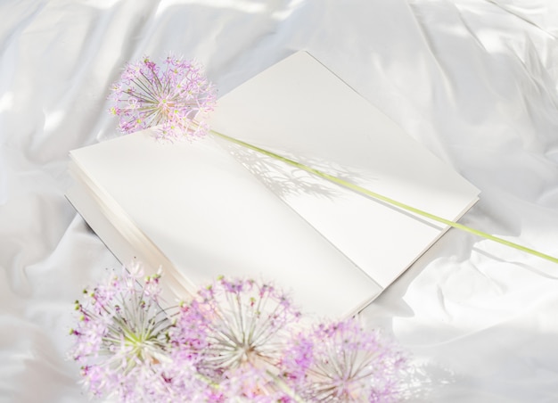 Flowers staying on open book in bed