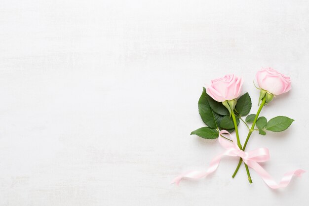 Flowers valentine day composition. Frame made of pink rose on gray background. Flat lay, top view, copy space.