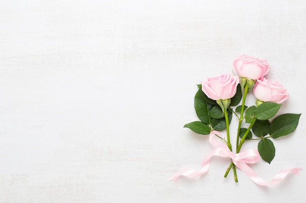 Flowers valentine day composition. Frame made of pink rose on gray background. Flat lay, top view, copy space.