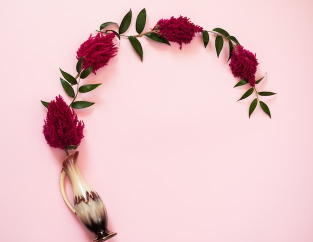 Flowers in vase lie on a pink background - Image