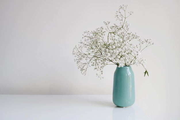 Photo flowers in vase on table against wall