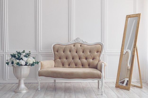 Flowers in Vase next to White Sofa