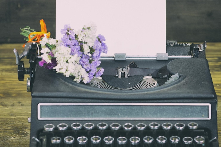 Photo flowers in vintage typewriter on table