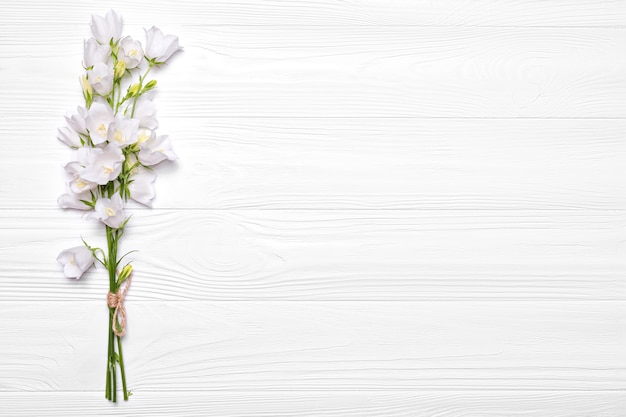 Flowers white bells on a white wooden background.