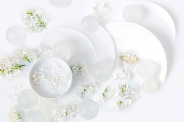 Flowers of white lilac and tea utensils in milk