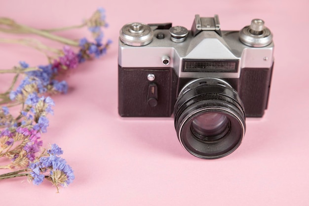 Flowers with vintage camera on the table