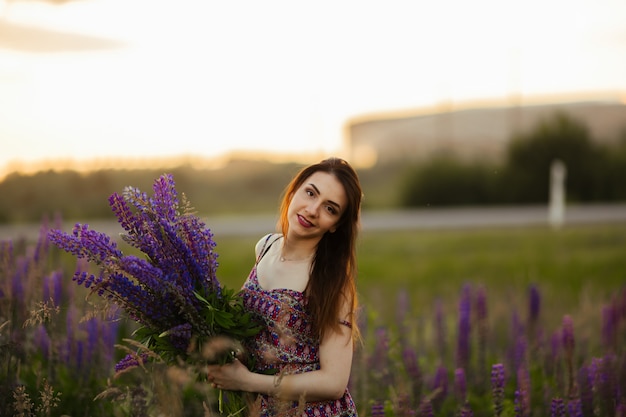 花とフィールドの女性の手のひら。点灯している夕方の太陽