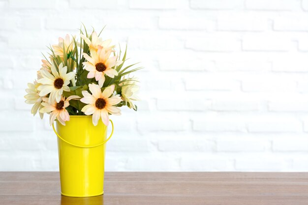 Flowers in the yellow pot on table with copy space