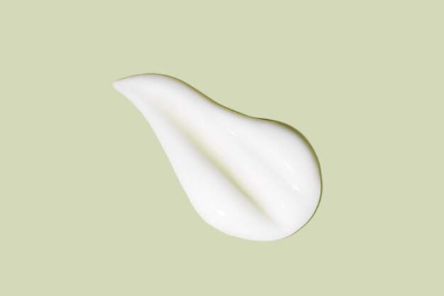 The flowing cream on a green background Smudged flowing smear of cosmetic cream