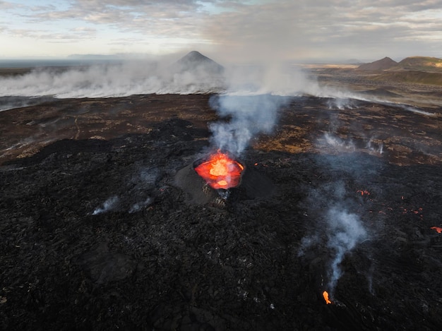 Flowing lava hot magma spilling out of the volcano crater aerial side view concepts of volcanic