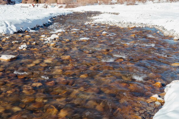 Flowing mountain river in winter