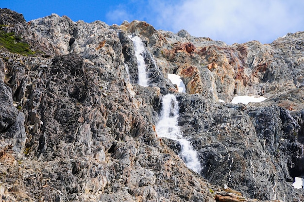 Flowing waterfall among rocky mountains