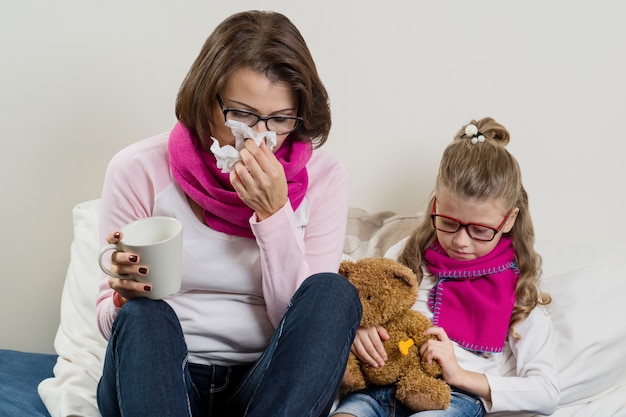 Flu season, sick mother and child at home