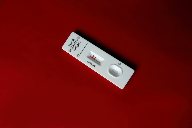 Photo flu a test kit, influenza a positive isolated on red background