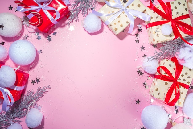 Fluffy Christmas concept. Festive Christmas background with fluffy decoration stuff, xmas ball, gift boxes, with artificial snow and shiny stars on pink color background copy space