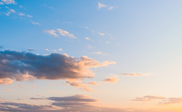 Photo fluffy clouds on a sunset background with dramatic light.