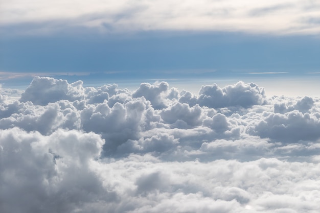 Над пушистыми облаками с голубым небом с самолета