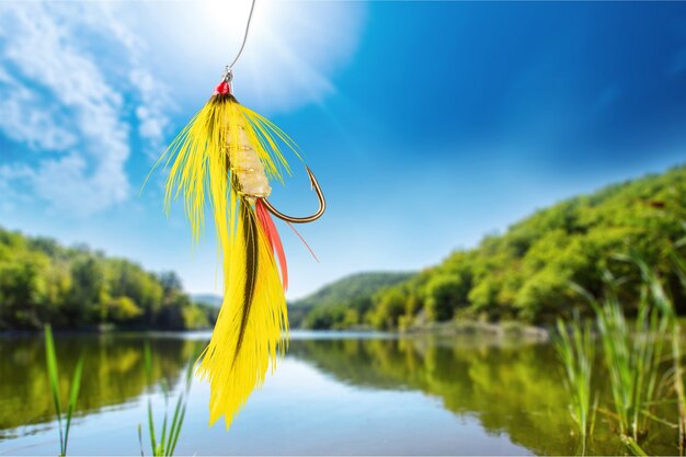 Fluffy fly fishing hook on background