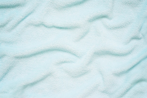 Fluffy Gentle baby blue fabric. Soft pastel textile texture. Folds on the soft fabric.