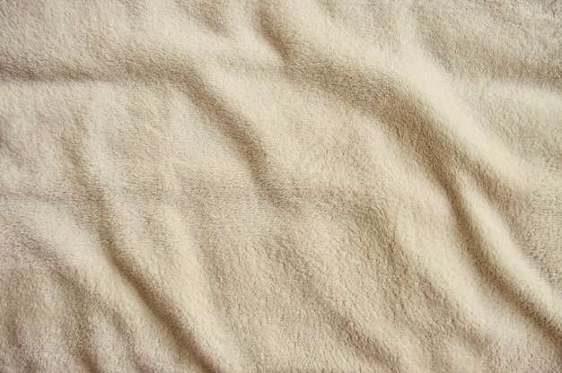 Fluffy gentle pastel beige fabric with waves and folds Soft pastel textile texture