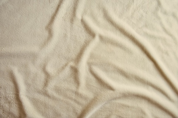 Fluffy gentle pastel beige fabric with waves and folds Soft pastel textile texture