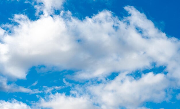 暖かい晴れた日の青い空を背景にしたふわふわの白い雲静かな生活のコンセプトとしての穏やかでゆっくりと浮かぶ雲