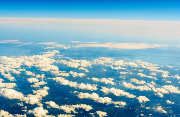 飛行機から見たふわふわの白い雲と青い空。フライトクラウドスカイ