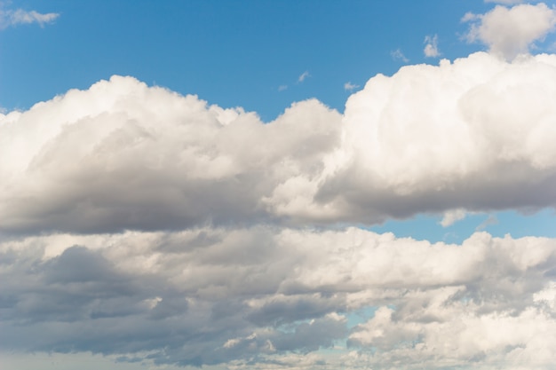 Fluffy white clouds in a blue sky in sunny summer day natural backdrop