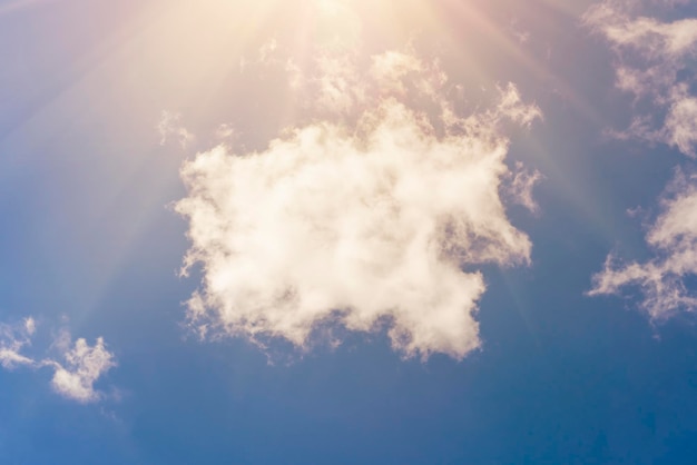 日光を背景に青い空にふわふわの白い雲